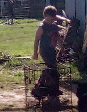2nd grade boy is walking by chicken in a cage on Ag Day 22